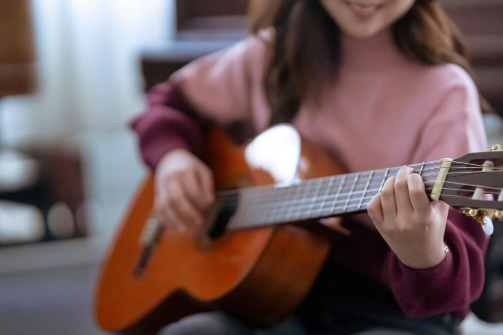Persona practicando guitarra para progresar en el aprendizaje