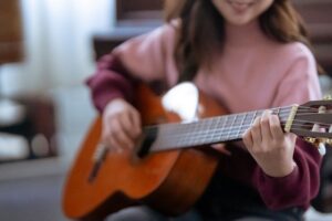 Persona practicando guitarra para progresar en el aprendizaje